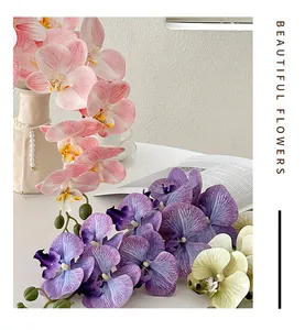 Detailed close-up of pink and purple faux orchids with realistic petal textures in a white vase