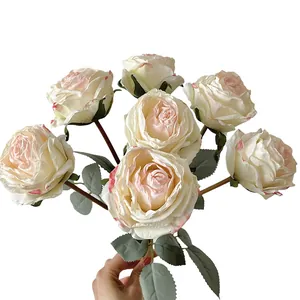 Bouquet de roses artificielles crème et rose tenu à la main pour décoration de mariage