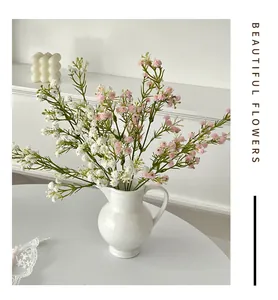 Detailed view of white and pink gypsophila bouquets in a ceramic vase for home decor