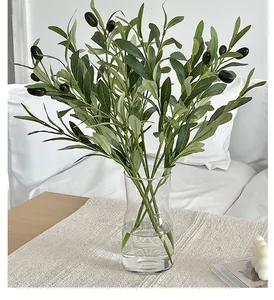 Detailed view of realistic artificial olive branch with green leaves and dark fruits