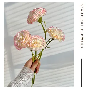 Detail of hand-held artificial carnations with pink serrated edges for home decor