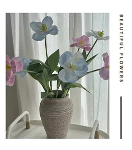 Detail of blue, pink, and white artificial tulips in a textured stoneware vase for home decor