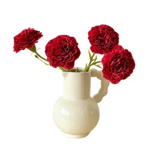 Artificial carnations in white ceramic vase for elegant home and bedroom decoration