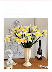 Détail de narcisses artificiels dans un vase en céramique strié pour la maison