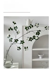 Detail of white artificial almond blossom branch in a glass vase for home decor