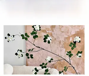 Close-up detail of artificial white apricot blossoms with green leaves and realistic petals