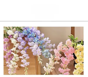 Close-up of silk delphinium petals in various colors resting on a wooden cabinet