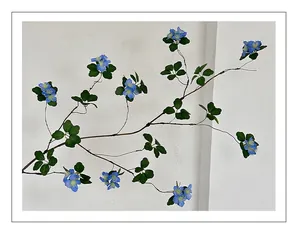 Detailed close-up of artificial blue apricot flowers and green leaves for home decor