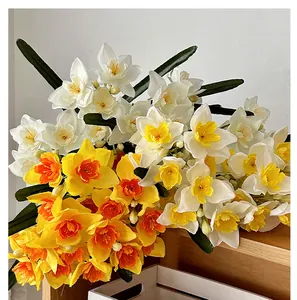 Détail de fleurs de narcisses artificielles réalistes avec feuilles sur bois chaud