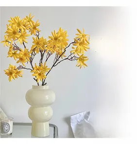 Dettaglio di orchidee gialle artificiali in un vaso di ceramica bianca creativo per interni