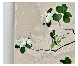 Detail of artificial white flowers with yellow centers and green leaves on black stems