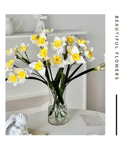 Narcisses artificielles en vase transparent avec statuette d'ange décorative