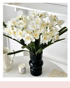 Détail de jonquilles artificielles blanches dans un vase noir texturé pour décoration intérieure