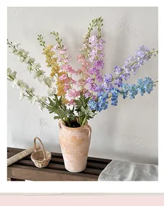 Close-up of multicolored silk delphinium flowers in a vintage ceramic vase