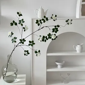 Artificial white apricot and green lotus branch in glass vase for minimalist home decor