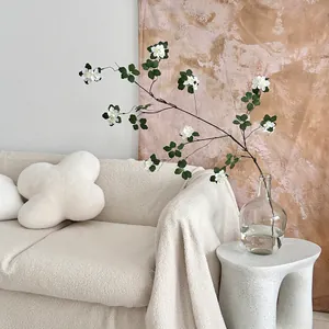 Artificial white apricot blossom branch in glass vase for minimalist home decor