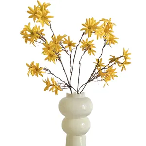 Margherite gialle artificiali in un vaso di ceramica bianca per decorazioni casa