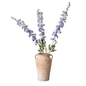 Artificial violet delphinium flowers in a vintage ceramic vase for home floral decoration