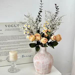 Vintage keramische vaas met zijden rozen en madeliefjes voor rustieke tafeldecoratie