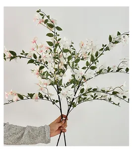 Detalle de pétalos degradados blanco y rosa en una rama de flor artificial decorativa