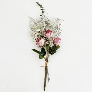 Kunstmatig boeket van roze rozen en witte madeliefjes gebonden met henneptouw
