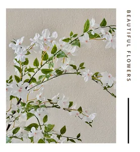 Primer plano detallado de flores blancas artificiales con hojas verdes y centro rosa
