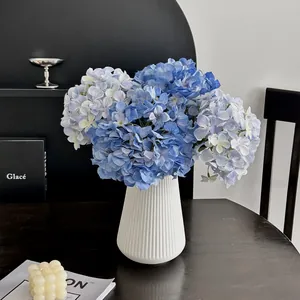 Jarrón moderno de cerámica blanca con hortensias azules 3D sobre mesa de madera