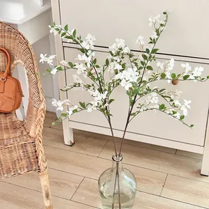Flores blancas artificiales en jarrón de vidrio para decorar el salón hogar