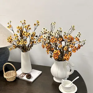 Kunstmatige madeliefjes in keramische vazen voor rustieke herfstdecoratie in de kamer