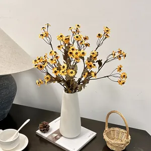 Kunstmatig boeket madeliefjes in een witte keramische vaas voor vintage decoratie