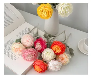 Macro shot of colorful artificial silk roses with vibrant petals and green leaves