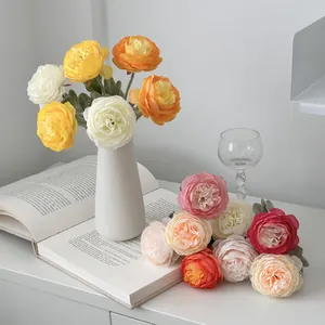 Artificial ranunculus flower arrangement in white ceramic vase for home table decor