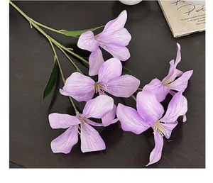 Detail van paarse kunstmatige orchidee met fijne bloemblaadjes op donkere houten basis