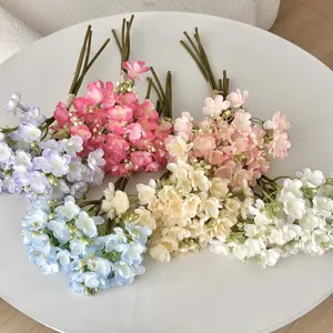 Kunstmatige jasmijnboeketten in paars, roze en wit op een schone witte ronde tafel