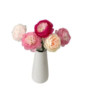 Faux ranunculus flower arrangement with five colorful petals in a white ceramic vase