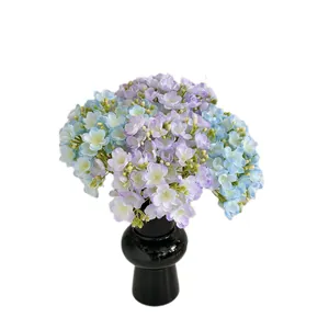 Nep jasmijn boeket in paars en blauw in een glanzende zwarte vaas voor huisdecoratie