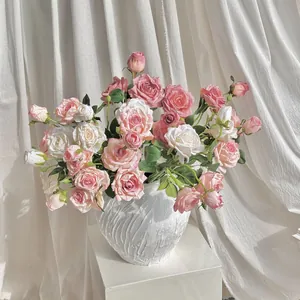 Rosas artificiales de estilo vintage en jarrón de cerámica blanca para decoración de casa