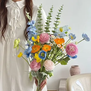 Artistic artificial silk bouquet with pink peonies and blue poppies for graduation photos