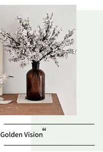 Flores de paniculata de seda blanca en jarrón de vidrio ámbar para decoración nórdica
