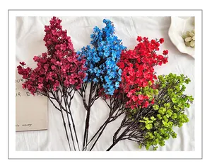 Flat lay of colorful silk baby's breath bouquets on white fabric for wedding decor
