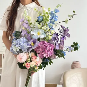Close-up of artificial bouquet featuring pink roses and purple hydrangeas held by a model