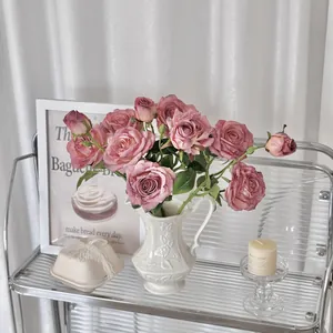 Rosas artificiales vintage en jarrón de cerámica blanca para decoración del hogar