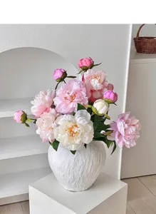 Gros plan détaillé de pivoines roses dans un vase blanc texturé pour décoration intérieure