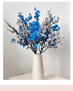 Detailed view of blue and white artificial flowers in a matte white ceramic vase for decor