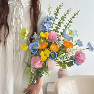 Close-up of a model holding a colorful artificial flower bouquet for home decoration
