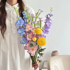 A bouquet of colorful artificial flowers being held by a woman in a white dress