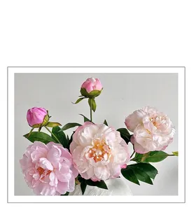 Gros plan de pivoine artificielle rose aux pétales réalistes dans un vase blanc gaufré