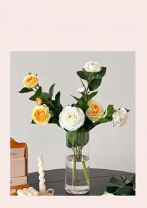 Dettaglio di fiori di camelia artificiali colorati in un vaso di vetro trasparente