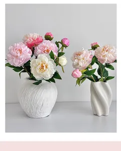 Gros plan de pivoines artificielles roses et blanches en vases de céramique