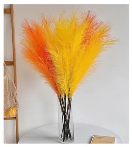 Détail de l'herbe de la pampa artificielle orange vif dans un vase en verre